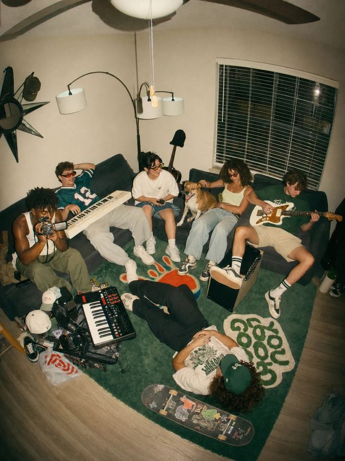 Friends with keyboards and a guitar hanging out in a living room